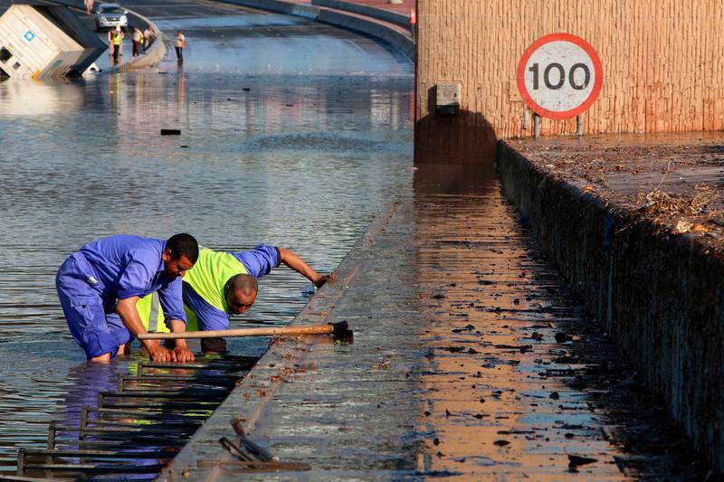 Municipality workers try to drain a flooded underpass in Kuwait City. AFP
