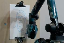 A Boston Dynamics AI Institute robot sketches a visitor's face during the International Conference on Robotics and Automation in London. AP