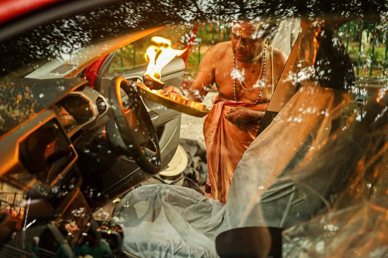 A priest performs a ritual on a newly purchased car to seek blessings from the deities for safety outside a temple in Bangalore. AFP