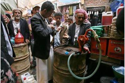 Yemenis buy fuel at a market in Sanaa: more petrol is being released on the market at unsubsidised prices.