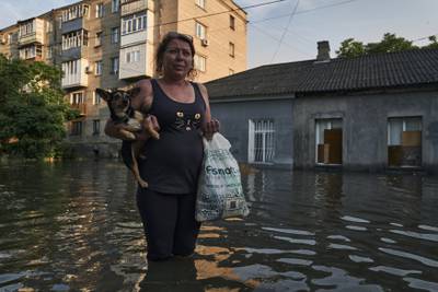 A woman walks along a flooded street in Kherson. AP