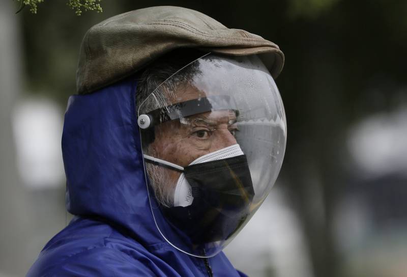 A man wearing a protective face shield and two mask waits be vaccinated in Quito, Ecuador. Elderly people waited hours to be inoculated. AP Photo