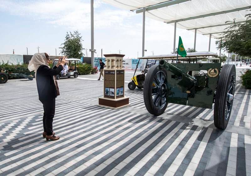 A woman takes a snapshot of the French cannon at Al Wasl Plaza