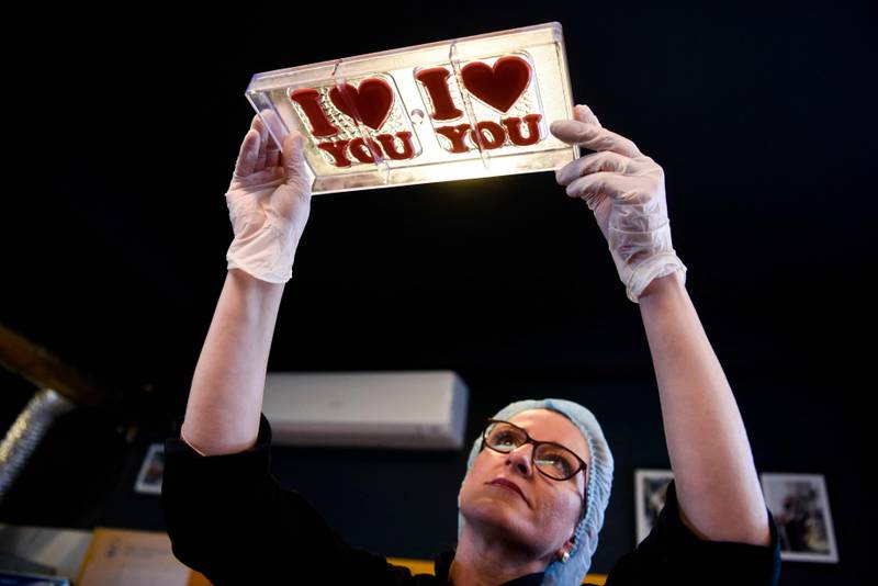 Trendeline Mucolli uses a tray to make heart-shaped chocolates at the Amel factory near Pristina, Kosovo. AFP