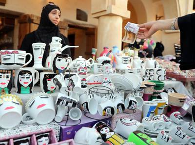 epa06537635 A Saudi women sells coffee mugs and cups with female faces drawings on them   at Al-Sharqiya (Eastern) Province pavilion during  Al- Janadria festival near Riyadh, Saudi Arabia, 17 February 2018. Al-Janadria festival is the biggest cultural heritage festival  held in Saudi Arabia, the 2018 edition opened on 07 February for 4 days to men only, then to families which translates to a mixed gender attendance. A few days after it opened though, the authorities announced it would last three weeks longer to enable Saudi people to enjoy visiting its government pavilions, cultural shows and exhibits and various entertainment representations present this year. The 2018 edition of the festival bore a fair atmosphere where Saudis get to have fun where it was frowned upon before, as part of the changes the countries has seen since 2017.  EPA/AMEL PAIN