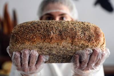 A baker holds up a seeded white loaf of bread at a bakery in Beirut, Lebanon, which faces a food crisis because of war in Europe. All photos: Bloomberg