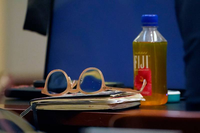 Depp’s glasses, beverage and sketchbook in the courtroom. AFP
