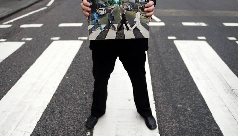 epa04345909 British actor Andrew Lancel who plays Brian Epstein in the London stage show 'Epstein' holds the album of Abbey Road at Abbey road. EPA