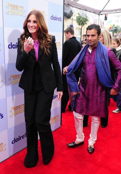 Actress Julia Roberts and director Tarsem Singh (R) arrive for the world premiere of the film 'Mirror Mirror' at Grauman's Chinese Theater in Hollywood on March 17, 2012 in California. Billed as a fresh and funny retelling of the Snow White legend, 'Mirror Mirror" opens in the US on March 30. AFP PHOTO/Frederic J. BROWN (Photo by FREDERIC J. BROWN / AFP)