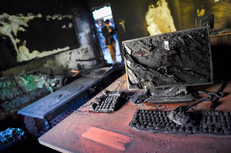 A photographer takes pictures inside a burned office of the National Legal Training center a day after gunmen stormed the university in Kabul. AFP