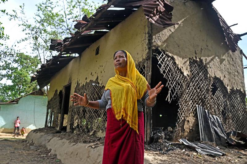 The mother of an alleged suspect in the viral sexual assault video during an interview in front of her partially charred house in Pechi Awang Leikai village, Manipur. AFP