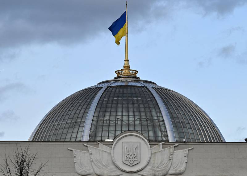 The Ukraine flag flutters over its parliament as the country declares a state of emergency. Experts have urged it to invite Nato peacekeepers to deter further Russian incursions. AFP