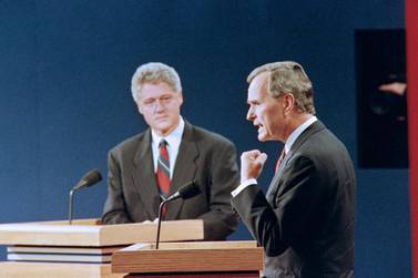 US President George Bush (R) answers a question while democratic Presidential candidate Bill Clinton listen on October 11, 1992 at the athletic center at Washington University in St Louis during the first of three US presidential debates.. (Photo by Eugene GARCIA / AFP)