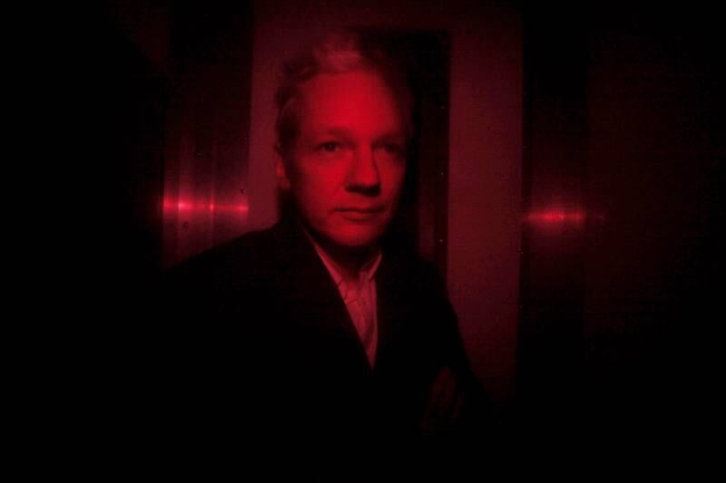 Mr Assange arrives at Westminster Magistrates' Court in a prison van with red windows in December 2010. Getty Images