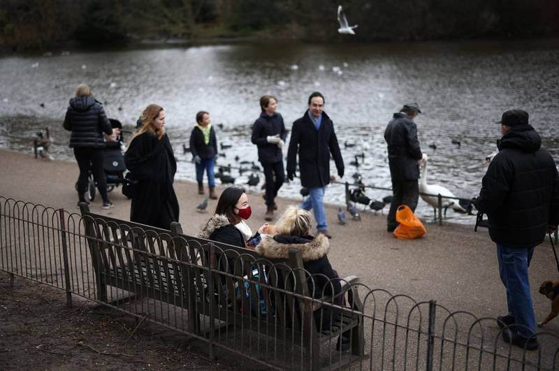 Two people sit on a bench in St James's Park in London. Reuters