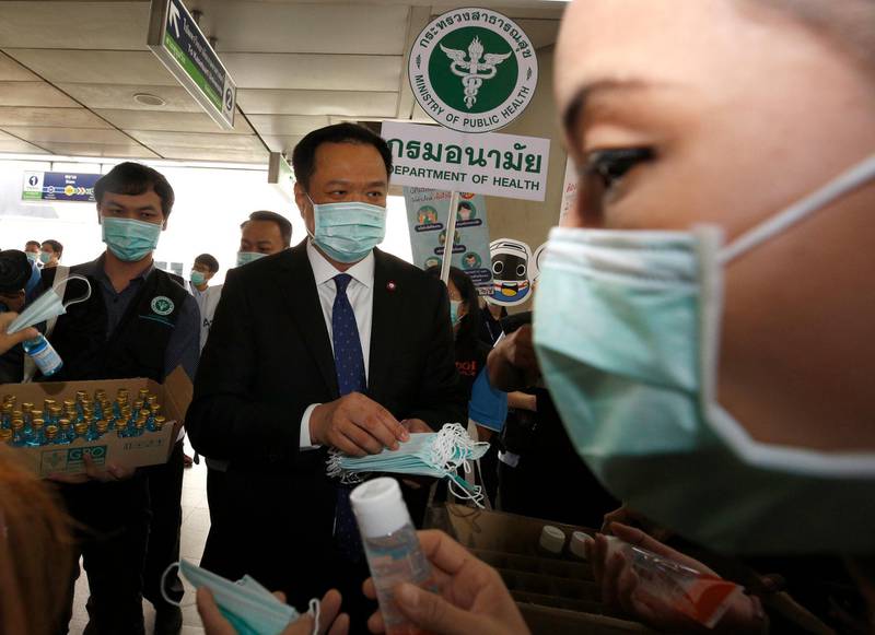 Thai Deputy Prime Minister and Public Health Minister Anutin Charnvirakul (C) distributes masks to the public during a campaign event held to encourage the public to wear masks and wash their hands thoroughly as part of coronavirus prevention, at a skytrain station in Bangkok, Thailand.  EPA
