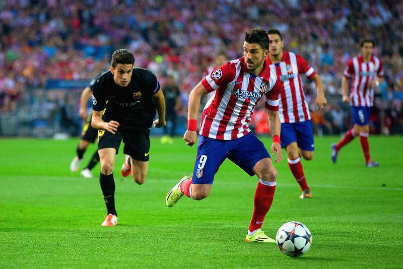 David Villa, right, of Atletico Madrid gets a step on Barcelona’s Marc Bartra during their Uefa Champions League game on Wednesday night. G Moreno / Getty Images

