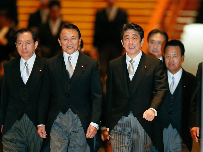 With Taro Aso, as deputy PM and finance minister, second left, Mr Abe has instilled "Abenomics" to nourish the country's slowing rate growth with an ageing population. EPA