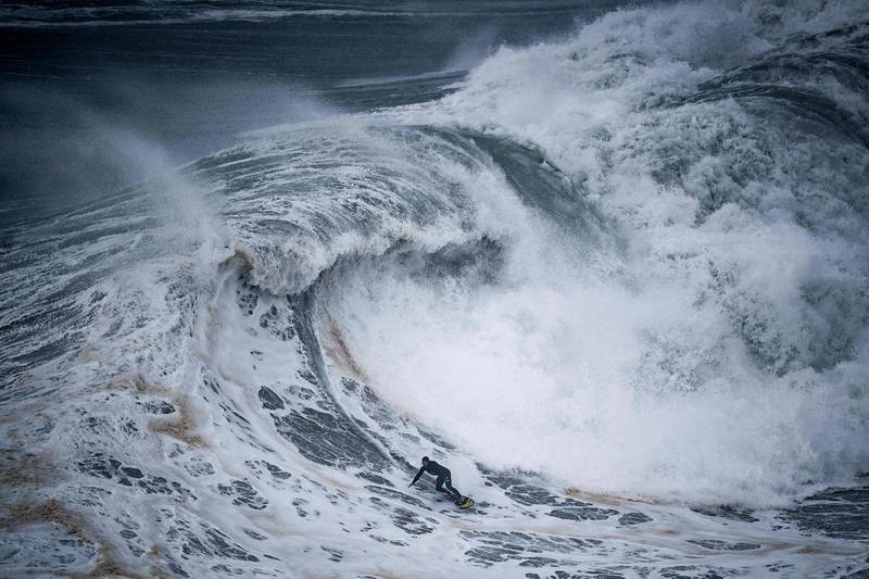 A surfer rides a wave at the Praia do Norte in Nazare in Portugal on December 11. AFP