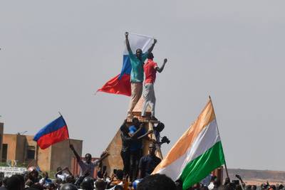 Protesters wave Nigerien and Russian flags as they gather outside the French embassy in Niamey for a rally in support of Niger's military junta. AFP
