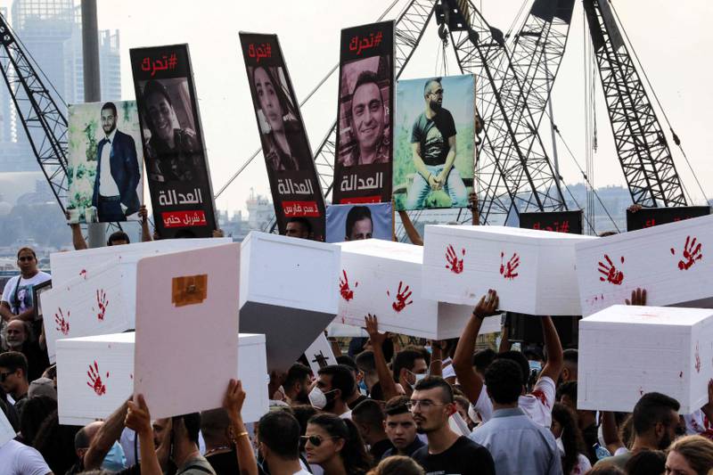 Activists and relatives of the victims carry makeshift coffins as they march in Beirut.  AFP