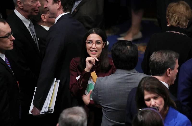 Rep. Alexandria Ocasio-Cortez talks to colleagues on the floor of the House after the House of Representatives approved two counts of impeachment against US President Donald Trump in Washington, December 18, 2019. Reuters