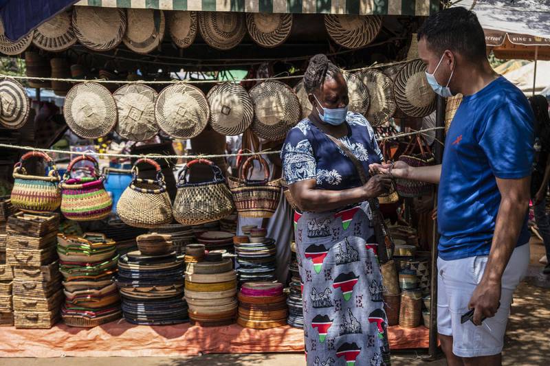At Nairobi's Maasai market, a customer tries on a traditional handmade bracelet, Kenya, December 5. Bloomberg
