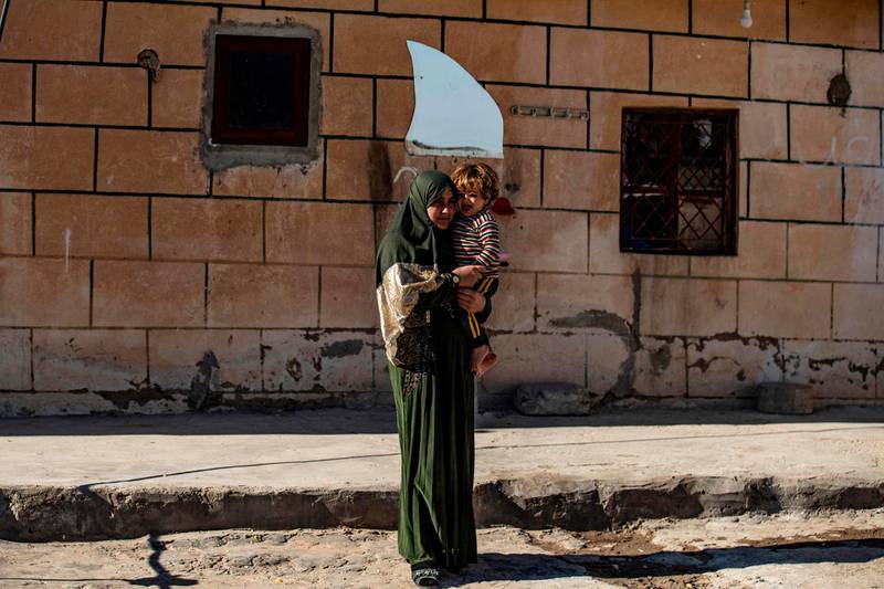 Rafidah Nayef Issa, a 22-year-old Iraqi Yezidi woman, carries her 2-year-old son at her home in al-Hasakeh, in northeastern Syria. AFP