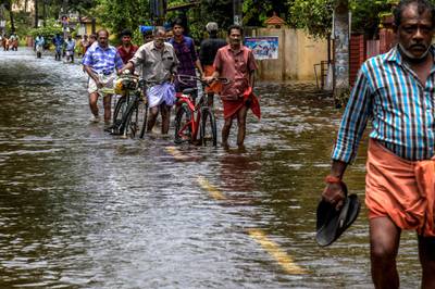 KERALA, INDIA - AUGUST 20: Locals cross flood water on route to  Chengannur on August 20, 2018 in Kerala, India. Over 350 people have reportedly died in the southern Indian state of Kerala after weeks of monsoon rains which caused the worst flooding in nearly a century. Officials said more than 800,000 people have been displaced and taken shelter in around 4,000 relief camps across Kerala as the Indian armed forces step up efforts to rescue thousands of stranded people and get relief supplies to isolated areas. (Atul Loke/Getty Images)
