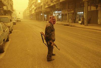 A militiaman patrols the streets of Baghdad, Iraq during a sandstorm March 26, 2003. AP