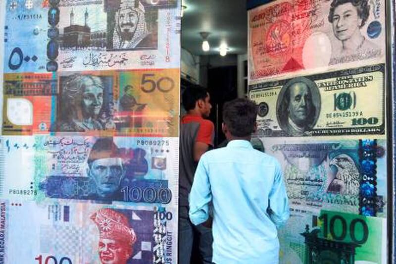 Pakistani customers enter a foreign currency exchange shop in Karachi on October 14, 2010. The dollar fell against most Asian currencies while the region's stock markets posted strong gains on growing expectations of new pump-priming measures by the US.  AFP PHOTO / RIZWAN TABASSUM

 *** Local Caption ***  413892-01-08.jpg