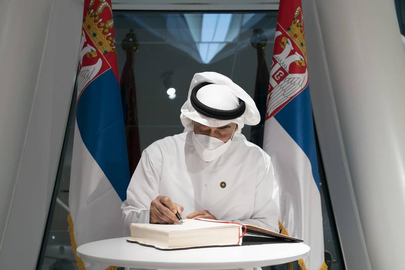 Sheikh Mohamed bin Zayed, Crown Prince of Abu Dhabi and Deputy Supreme Commander of the Armed Forces, signs the visitors' book at the Serbia pavilion, during a visit to Expo 2020 Dubai.