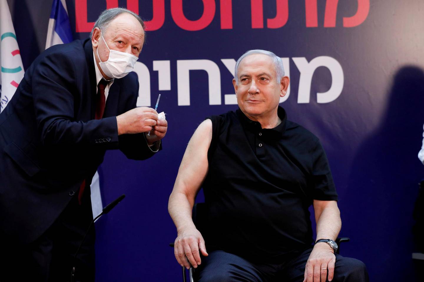 Israeli Prime Minister Benjamin Netanyahu gets ready to receive a coronavirus vaccine at Sheba Medical Center in Ramat Gan, Israel on Saturday, Dec. 19, 2020. (Amir Cohen/Pool via AP)