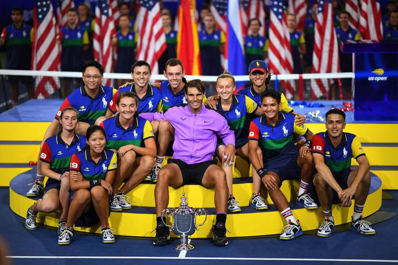 Rafael Nadal of Spain and the ball people pose with the trophy. AFP