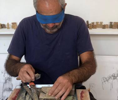 Blindfolded, Kourbaj carves the miniature eye idols out of Aleppo soap that collectively form 'Don’t Wash Your Hands: Neither Light Agrees to Enter the Eyes Nor Air the Lungs'. Sami Kourbaj