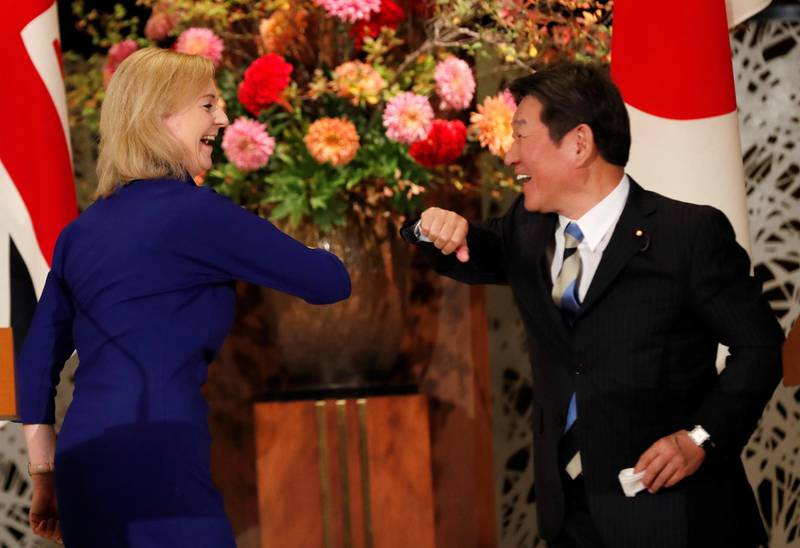 Britain's International Trade Secretary Elizabeth Truss and Japanese Foreign Minister Toshimitsu Motegi bump elbows during their news conference following a signing ceremony of the UK-Japan Comprehensive Economic Partnership Agreement in Tokyo, Japan October 23,2020.  REUTERS/Kim Kyung-Hoon