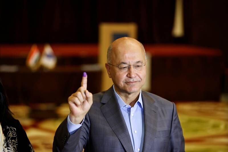 President Barham Salih holds up his inked finger at a polling station in Baghdad. Photo: Reuters