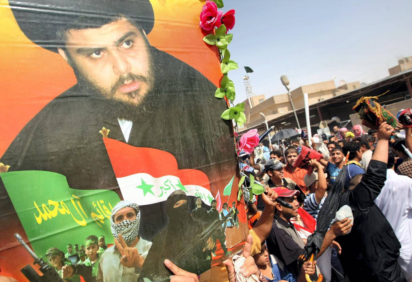 Shiite Muslims protest close to an image of anti-US cleric Moqtada al-Sadr during a protest following Friday noon prayers in the impoverished Sadr City neighborhood of eastern Baghdad on September 19 2008. The weekly Friday prayers have recently been followed by protests in support of radical cleric Moqtada al-Sadr and against the occupying US forces.  AFP PHOTO/AHMAD AL-RUBAYE
 / AFP PHOTO / AHMAD AL-RUBAYE