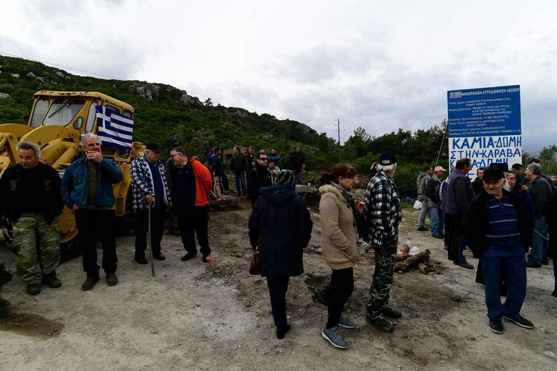 Greece's government hopes to defuse tensions after protests over plans for new migrant camps. AP