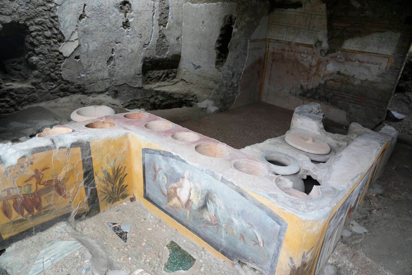 Un thermopolium, un établissement commercial où il était possible d'acheter des aliments prêts à manger, est visible à l'intérieur du site archéologique de Pompéi.  AP Photo