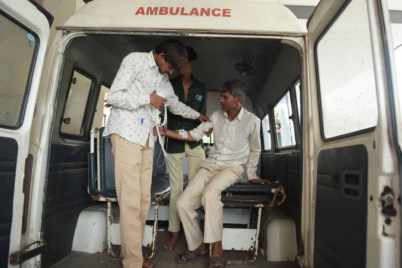 A man, right, arrives in an ambulance at the Civil Hospital in Ahmedabad on Tuesday after suffering health problems, allegedly after drinking bootleg liquor.  AFP