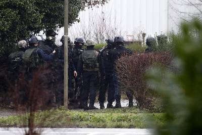 Police officers take position at an industrial area where the suspects are reportedly holding a hostage. Etienne Laurent / EPA