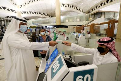 A traveller has his passport checked at an immigration counter at the King Khalid International Airport in Riyadh after Saudi Arabia lifted a travel ban on its citizens. Reuters