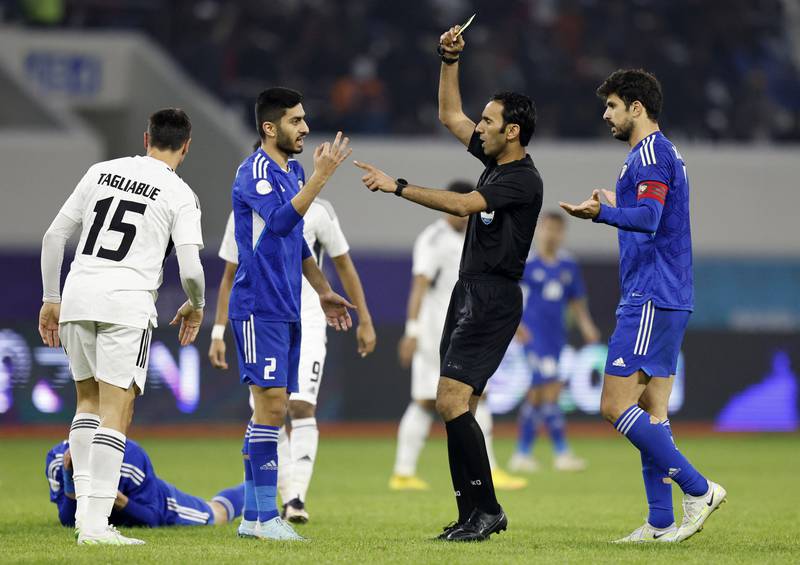 UAE striker Sebastian Tagliabue is shown a yellow card. Reuters
