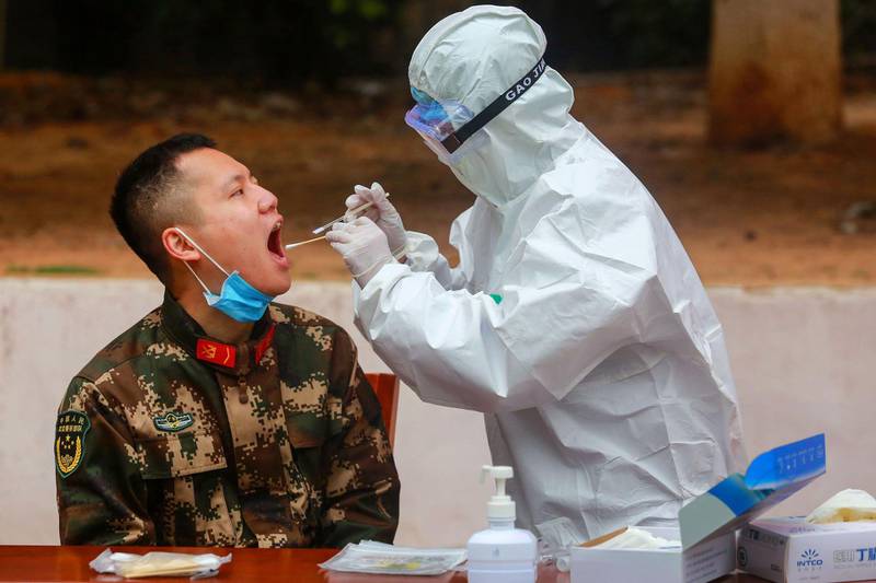 Medical staff members collect samples from Chinese paramilitary police officers as he returns from holidays in Shenzhen in China's southern Guangdong province. AFP