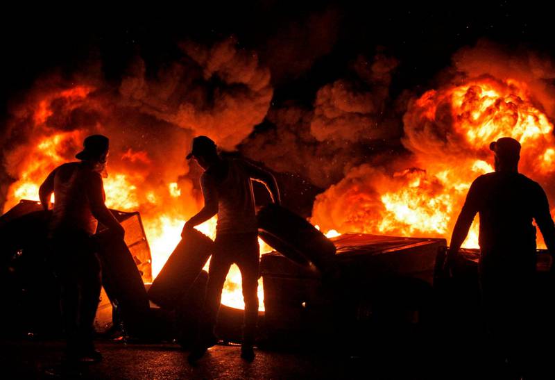 Protesters set dumpsters and tyres alight as they block a road in the southern Lebanese city of Sidon. AFP