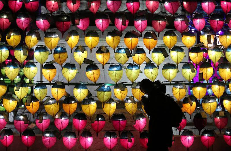 A woman prays in front of a wall of lanterns to celebrate the New Year at the Jogyesa Buddhist temple in Seoul, South Korea. AP Photo