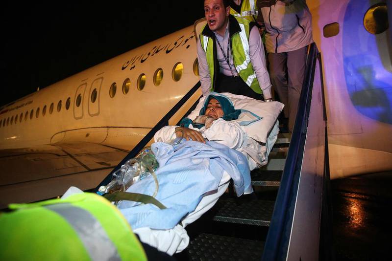Paramedics carry a wounded Iranian woman from a plane after arriving in Tehran's Mehrabad airport, a day after she was injured in twin suicide bombings near the Iranian embassy in Beirut. Amir Kholousi / AFP



