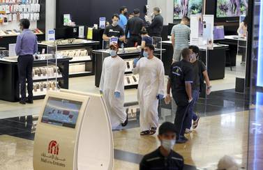 Shoppers wear protective face masks at the Mall of the Emirates in Dubai. Pawan Singh / The National