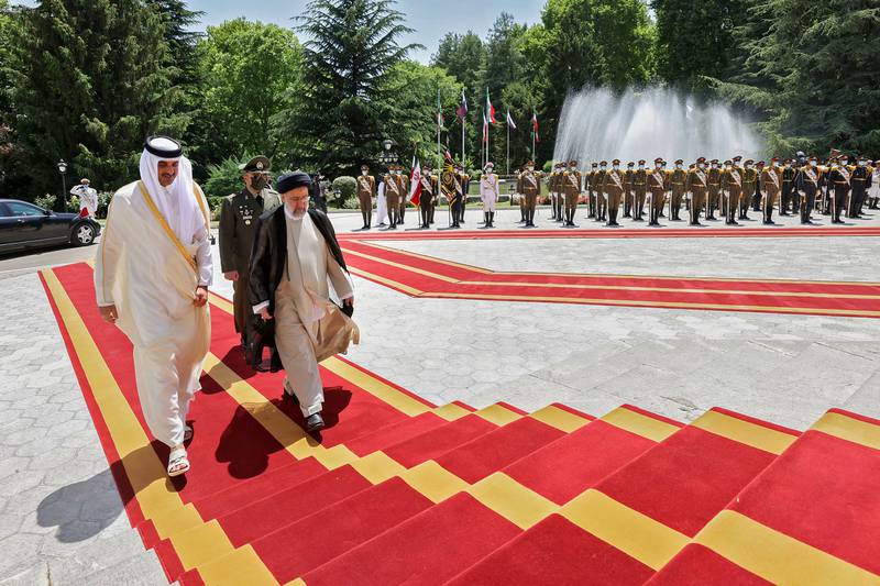 Mr Raisi walks with Sheikh Tamim at the presidential palace. AFP